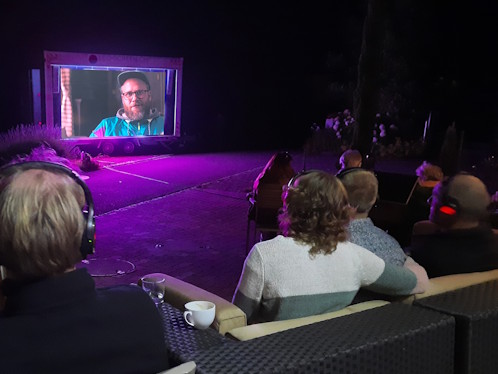Outdoor‑Kino mit Zuschauern auf Funkkopfhörern bei nächtlicher Silent‑Vorführung, ideal für leise Events ohne Lärmbelästigung
